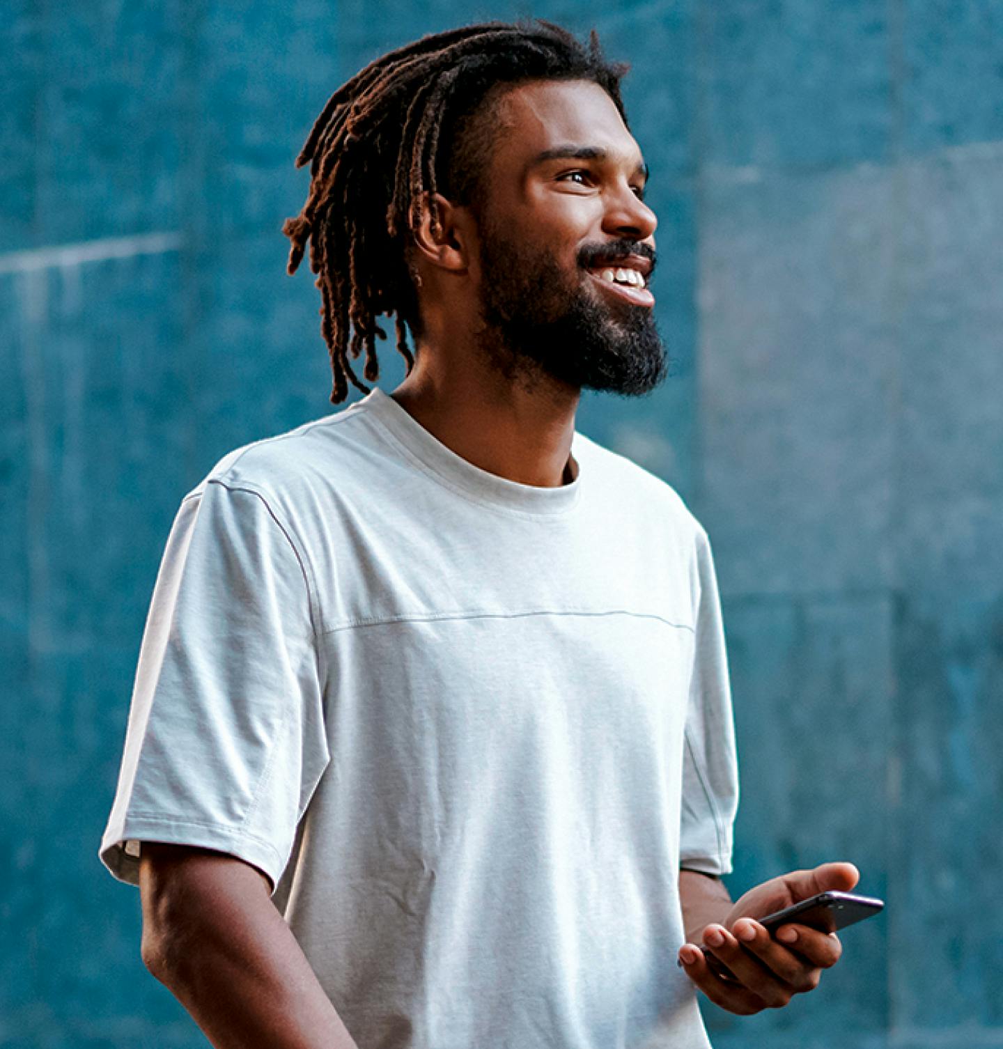 Homem negro sorrindo com um celular na mão